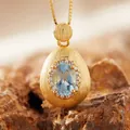 Macro view of a blue gemstone pendant with a brushed gold finish and stone accents - Natural Topaz Necklace Gold