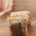Close-up of a gold-plated silver bracelet featuring a central blue oval gemstone - Natural Topaz Bracelet