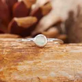 Primo piano di un anello d'argento con opale rotondo su pietra naturale - Opale