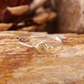 Elegant S925 silver ring featuring a round citrine gemstone on a natural rock surface - Citrine