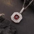 Close-up of square red gemstone pendant with double halo of white stones on dark rock - Natural Garnet / Silver