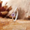 Close-up view of a minimalist S925 silver ring with a round purple amethyst stone - Amethyst