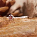 Detailed macro view of S925 silver ring with natural round garnet gemstone inlay - Garnet