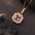 Detailopname van een gouden hanger met paars kristal en zirkoon-halo op de steen - Natuurlijke Amethist / Goud