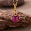 Detailed view of a round red agate pendant set in a 925 sterling silver gold-plated frame - Natural Red Corundum Style (N470) / Gold