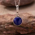 Macro view of round lapis lazuli pendant on silver chain against natural stone - Natural Lapis Lazuli Style (N470) / Silver