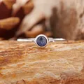 Dettaglio di uno zaffiro blu tondo incastonato in un anello di argento S925 lucido. - Zaffiro