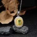 Detail view of oval S925 silver pendant with green gemstone on rustic stone background - Peridot (LN265)