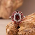 Detailansicht eines S925 Sterlingsilberrings mit ovalem Granat und Doppelhalo-Steinen. - Ring / Natur Granat / Rot
