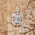 Detailed macro of S925 silver pendant with emerald cut blue gemstone and brushed feathers - Natural Topaz Necklace