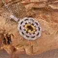 Close-up detail of a silver pendant with yellow citrine and white crystals on rock - Natural Citrine Necklaces