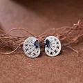 Gros plan de boucles d'oreilles rétro en argent S925 avec gemme bleue et pavé de pierres. - Style Saphir Naturelle