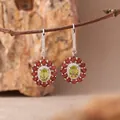 Nahaufnahme von S925 Silberohrringen mit leuchtenden grünen und roten Edelsteinen - Ohrstecker / Natürlicher Peridot / Grün