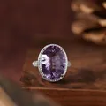 Close-up detail of a large oval purple amethyst ring with a sparkling stone halo. - Natural Amethyst Ring / 1 Piece