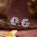 Detailansicht von S925 Silber Gänseblümchen-Ohrringen mit lila Edelsteinen auf Holz - Ohrstecker / Natürlicher Amethyst