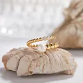 Detailed view of gold beaded open ring with freshwater pearl and CZ accents on rock prop - Natural Pearl Ring / Gold