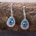 Close-up of teardrop blue topaz earrings in S925 sterling silver with halo stones - Natural Topaz