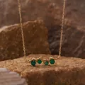 Close-up of a textured gold-tone necklace pendant featuring round green agate stones. - Green Agate Necklace / Gold