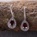 Detailed macro view of S925 sterling silver teardrop earrings with vibrant red garnet stones - Natural Garnet