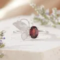 Close-up detail of a sterling silver butterfly ring with an oval red garnet gemstone - Natural Garnet Ring