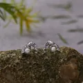 Close-up of elegant S925 sterling silver pearl stud earrings on a textured rock - Pearl Stud Earrings / Silver