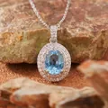 Detailed macro shot of an oval blue gemstone pendant with double diamond halo. - Natural Topaz Necklace