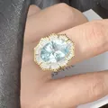 Victorian style gold ring featuring an oval light blue gemstone and diamond cluster - Natural Millennium Cut Topaz
