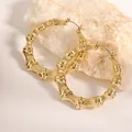 Primer plano de pendientes de aro dorados estilo bambú sobre fondo de piedra blanca - Estilo de Aro de Bambú (Oro 00032-5cm) / Dorado