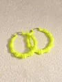 Detailansicht der neongelben Creolen im Bambus-Stil für einen Hip-Hop-Mode-Look - Fluoreszierendes Gelb
