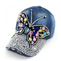 Detailed macro shot of a butterfly rhinestone design on a blue distressed denim baseball cap. - Adult, Hat Circumference 58cm Adjustable / Light Blue