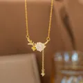 Delicate gold-toned necklace featuring a white resin rose and wheat ear pendant with a zircon drop - Rose Tassel Necklace (8407)