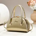 Elegant golden metallic evening handbag featuring a large crystal clasp and top handles. - Glossy Style / Gold