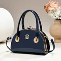 Elegant detail view of a navy blue patent leather evening handbag featuring a luxury crystal clasp - Glossy Style / Blue