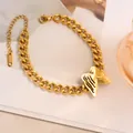 Gros plan d'un pendentif papillon doré sur un bracelet en chaîne en acier inoxydable - Sl5165j five-layer butterfly bracelet gold