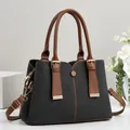 Close-up of stylish contrast color handbag with premium textured fabric and brown leather handles - Patchwork Contrast Style / Black