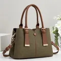 Vue détaillée d'un sac cabas en toile vert armée avec poignées en similicuir marron et dorés - Vert