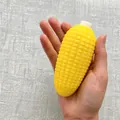 Yellow corn-shaped squishy stress relief toy held in hand, measures 11x5cm and weighs 75g. - Building Block Corn Squishies