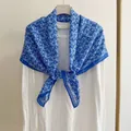 Vista dettagliata di un foulard quadrato floreale da 90cm blu e bianco su una maglia bianca - 90x90cm / Blu