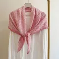 Vista dettagliata di un foulard quadrato a fiori rosa su un top bianco su una gruccia - 90x90cm / Rosa chiaro