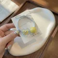 Gros plan d'un élastique à cheveux argenté avec pendentif coeur jaune et perle - Cœur Jaune Nœud Papillon (A025-3) / Curcuma