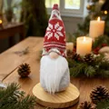 Detail view of a Christmas gnome with a red knitted snowflake hat on a wooden base - W-QT138 Red Snowflake Hat/Grey Body