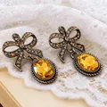 Detailansicht der Vintage-Ohrringe mit Schleifen-Design und gelben Kristallen im Gold-Look - Schleifenstil (13#)