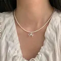 Elegant white pearl necklace featuring a delicate silver bow pendant worn by a model - Single Layer Pearl Bowknot Style (XL2076)