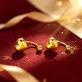 Elegantes pendientes de botón con forma de corazón dorados y acabado metálico pulido. - Color Oro Superior Corazón Forma U