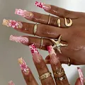 Main de mannequin avec faux ongles roses à fleurs 3D, accents dorés et bagues élégantes. - Style Fleur 3D Étoile de Mer Marbre Rose (M-B321) / 24 Pièces/Ensemble