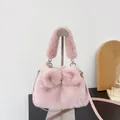 Elegant soft pink faux fur handbag featuring a bow design and silver heart-shaped hardware - Pink