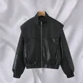Close-up of black faux leather bomber jacket featuring wide shoulders and zip front - S / Tops / Black 1