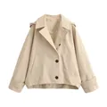 Detailed view of a stylish beige hooded cape windbreaker jacket featuring dark buttons. - XS / Tops / Light Khaki