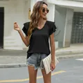 Outdoor lifestyle shot of woman in black V-neck t-shirt with double ruffle sleeves - M / Tops / Black