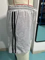 Detail view of women's grey athletic shorts featuring double black side stripes and pocket - S / Bottoms / Gray
